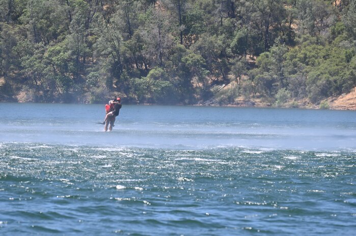 A Sikorsky HH-60G Pave Hawk lowers a pair of U.S. Air Force pararescue jumpers from the 129th Rescue Wing into Englebright Lake, Smartsville, California on June 6, 2024