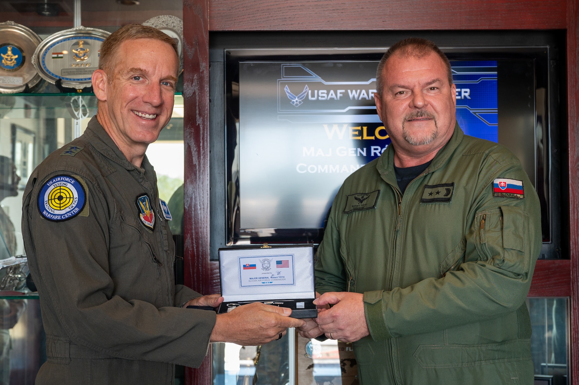 U.S. and Slovak Air Force Airmen holding a token of appreciation while posing for the camera