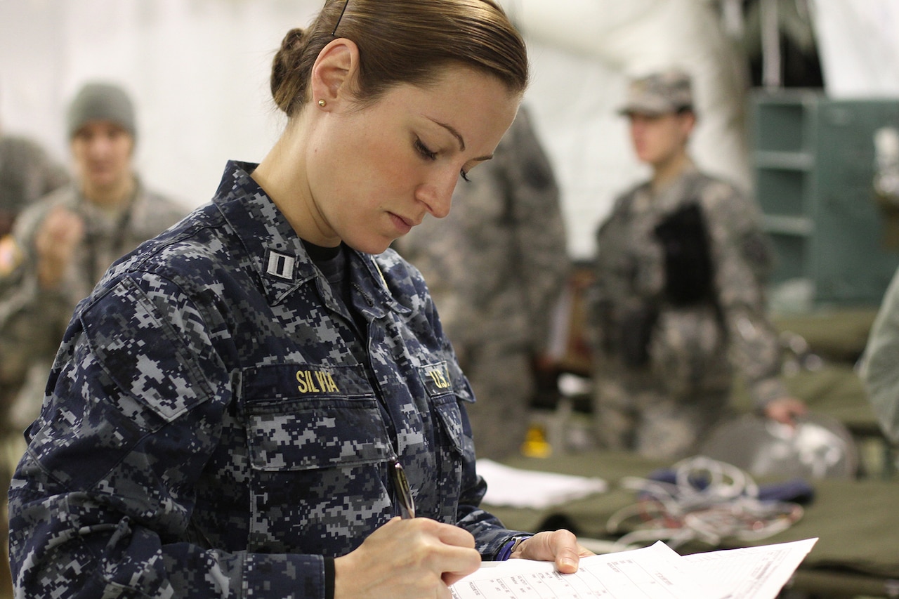 A sailor writes on a piece of paper.