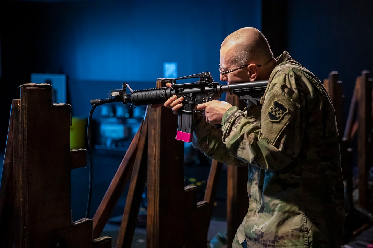 A soldier aims a weapon in a training facility.