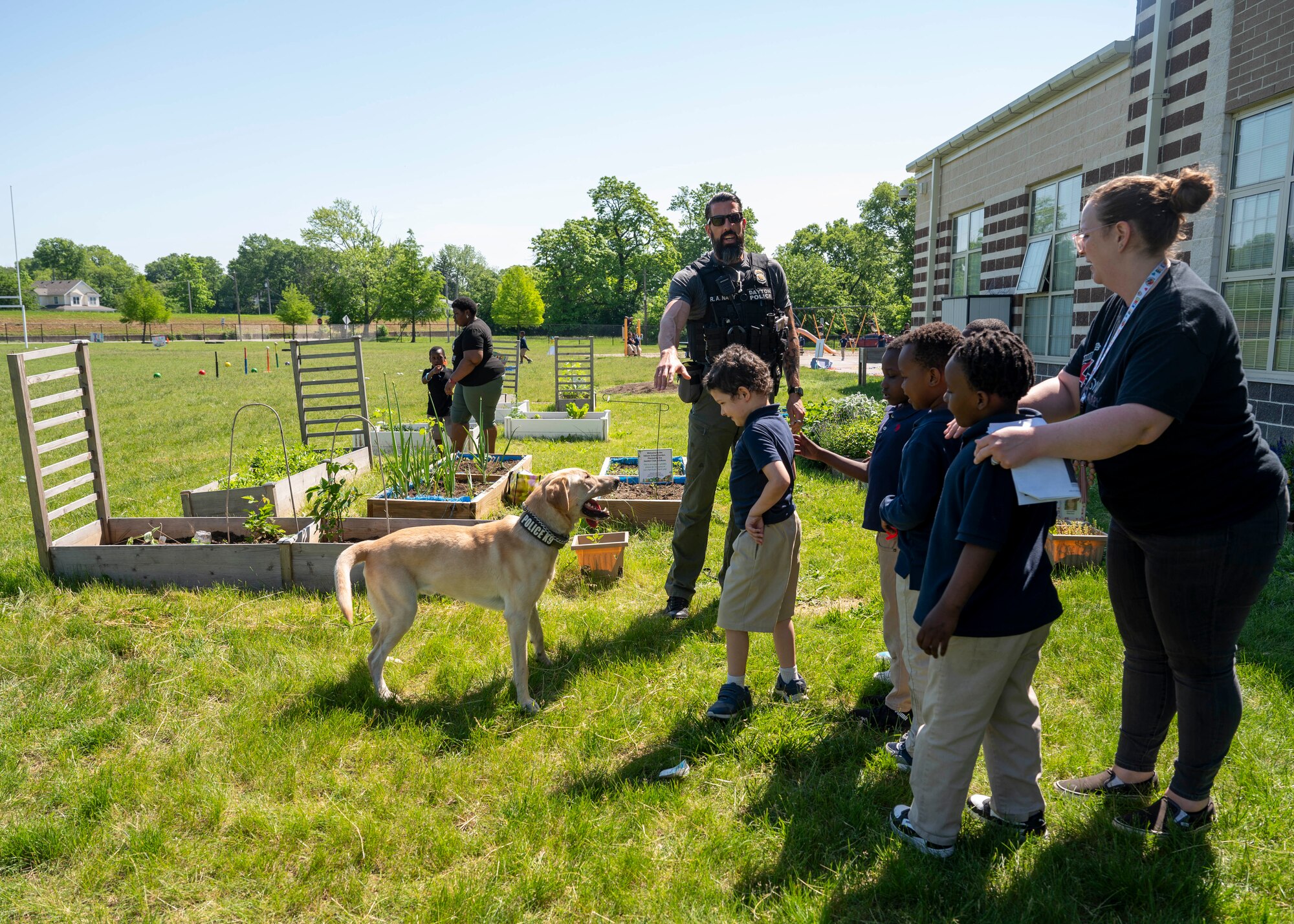 A law enforcement officer with the Dayton Police Department brought his working dog to provide a demonstration to the children at Edison Elementary School during an end of the school year field day in Dayton, Ohio, May 16, 2024. Members of AFLCMC volunteer yearly with the local school to help with this large event. (U.S. Air Force photo by Staff Sgt. Mikaley Kline)