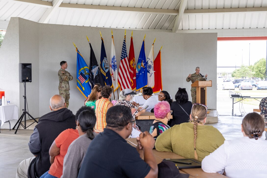 A group of people listen to a speech.