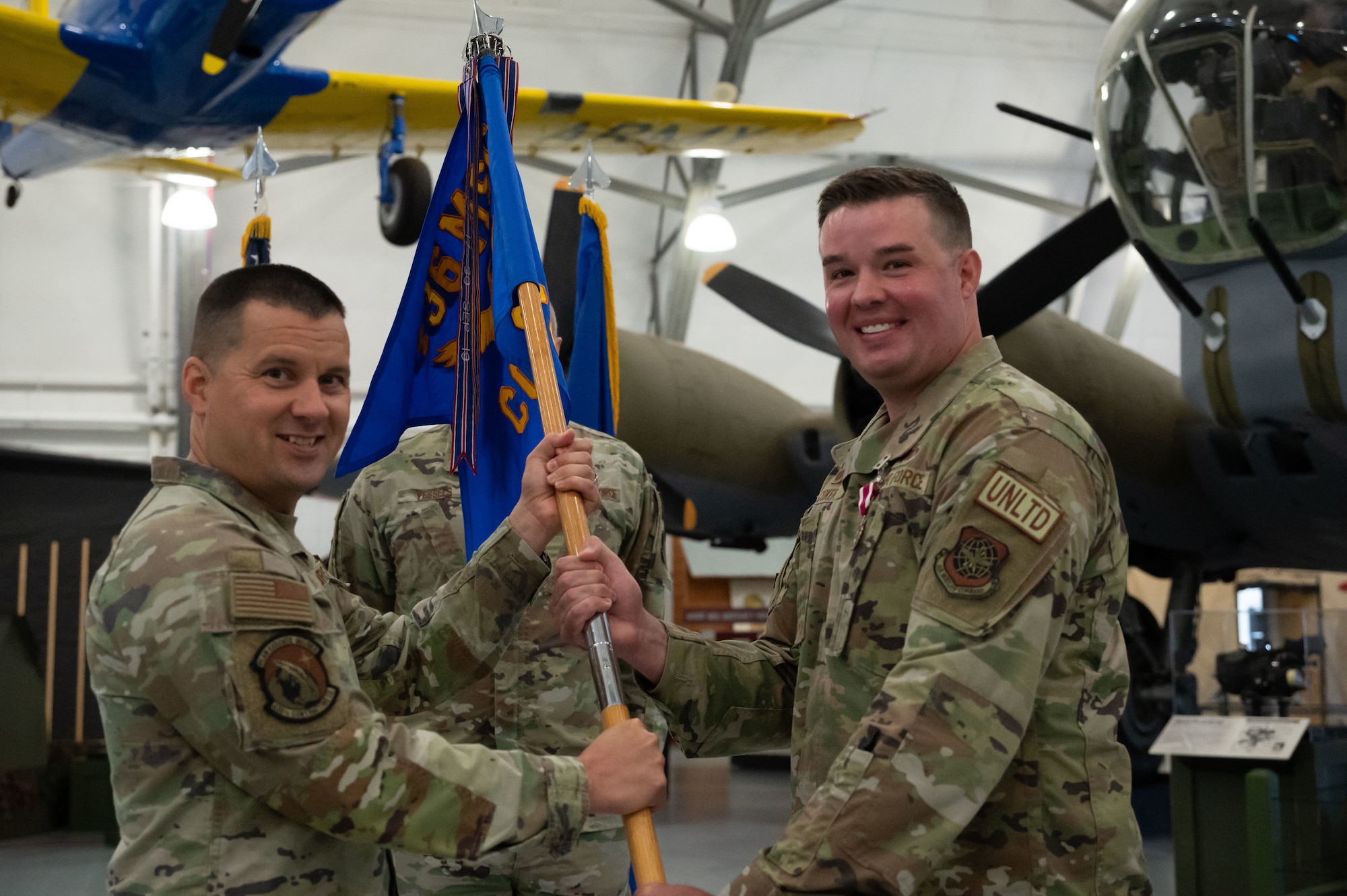 U.S. Air Force Maj. Ryan Coker, right, outgoing, 436th Contracting Squadron commander, passes the guidon to Col. Jason Holcomb, 436th Mission Support Group commander, during a change of command ceremony at Dover Air Force Base, Delaware, June 18, 2024. The ceremony saw Coker relinquish command to Maj. James Cashwell. (U.S. Air Force photo by Dieondiere Jefferies)