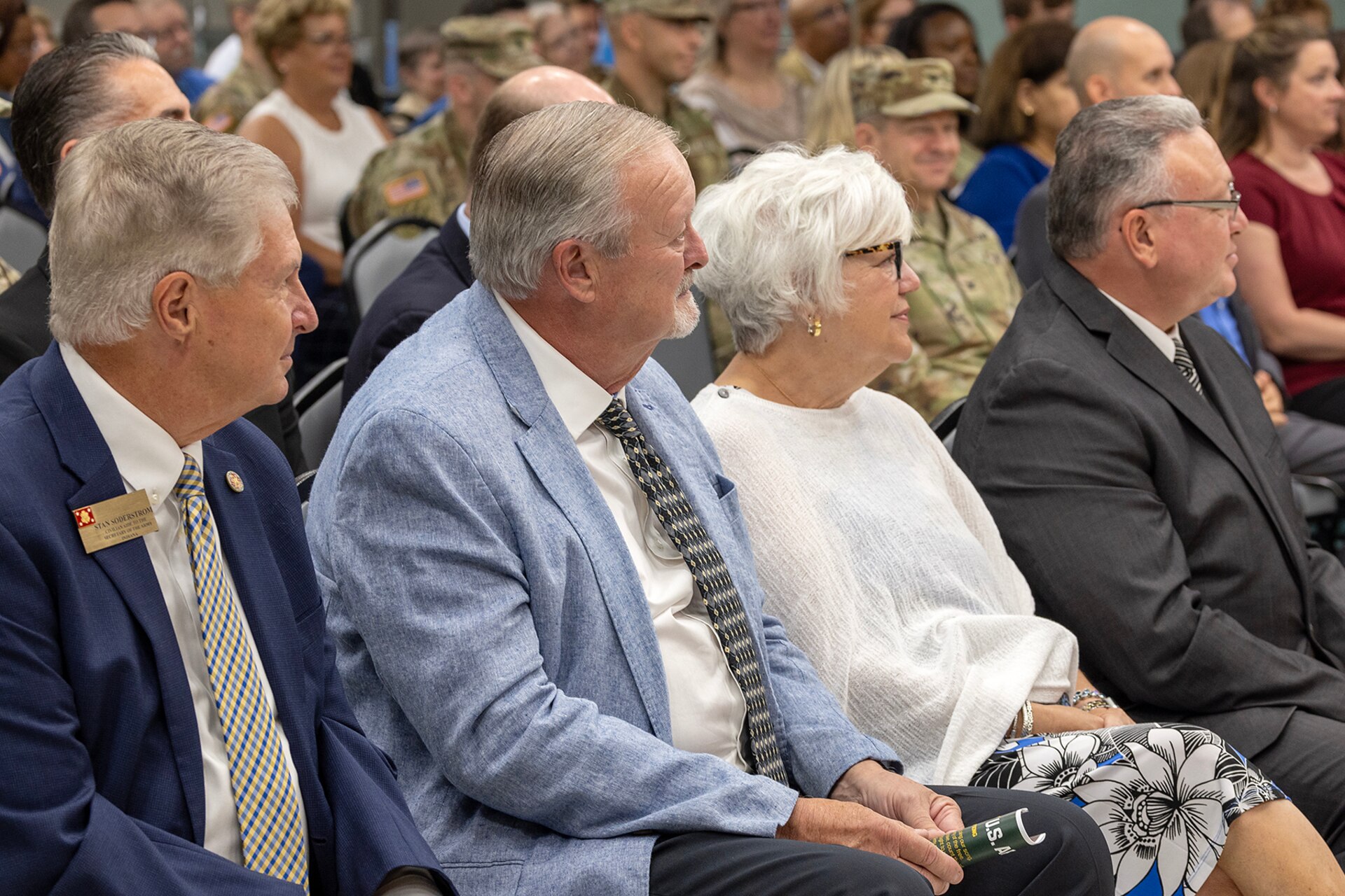 Stan Soderstrom, Civilian Aide to the Secretary of the Army for Indiana; Lee and Cindy Williams, parents of Col. Michelle M. Williams, U.S. Army Financial Management Command commander; and retired U.S. Coast Guard Capt. Jeff Pashai, Williams’ husband, listen during a USAFMCOM change of command ceremony at the Maj. Gen. Emmett J. Bean Federal Center in Indianapolis June 18, 2024. Williams, a St. Louis native, received a Regular Army commission into the Finance Corps in 1999 as a distinguished military graduate of the Florida Institute of Technology’s Army Reserve Officer Training Corps program after earning a Bachelor of Science in business administration. (U.S. Army photo by Mark R. W. Orders-Woempner)