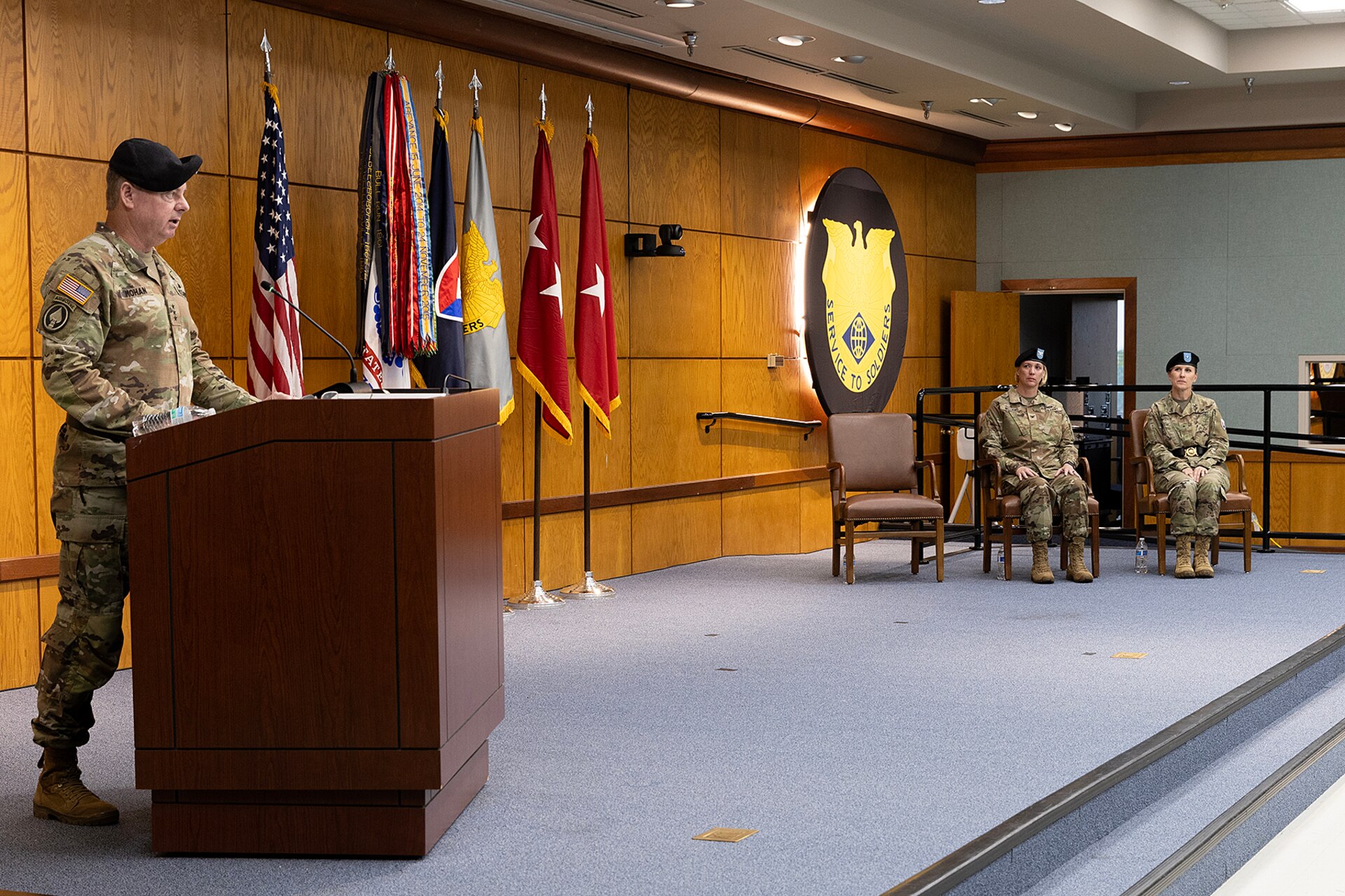 Lt. Gen. Christopher O. Mohan, U.S. Army Materiel Command deputy commanding general and acting commander, delivers remarks as Brig. Gen. Paige M. Jennings, outgoing U.S. Army Financial Management Command commanding general, and Col. Michelle M. Williams, incoming USAFMCOM commander, listen during a USAFMCOM change of command ceremony at the Maj. Gen. Emmett J. Bean Federal Center in Indianapolis June 18, 2024. USAFMCOM delivers precision enterprise-wide financial operations to integrate, synchronize and sustain the battlefield through the Joint Strategic Support Area and directly supports the Office of the Assistant Secretary of the Army for Financial Management and Comptroller in their role as the principal advisor on all matters related to financial management and comptrollership. (U.S. Army photo by Bradley A. Staggs)