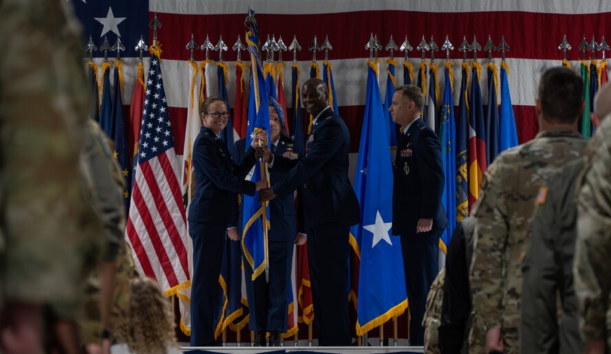 U.S. Air Force Col. Kenneth McGhee, outgoing 91st Missile Wing (MW) commander, gives the guidon to U.S. Air Force Maj. Gen. Stacy Huser, 20th Air Force commander, during the 91st MW change of command ceremony at Minot Air Force Base, North Dakota, June 18, 2024. McGhee gave the guidon to Huser during the ceremony, symbolically being relieved of his command of the 91st MW. (U.S. Air Force photo by Airman 1st Class Alyssa Bankston)