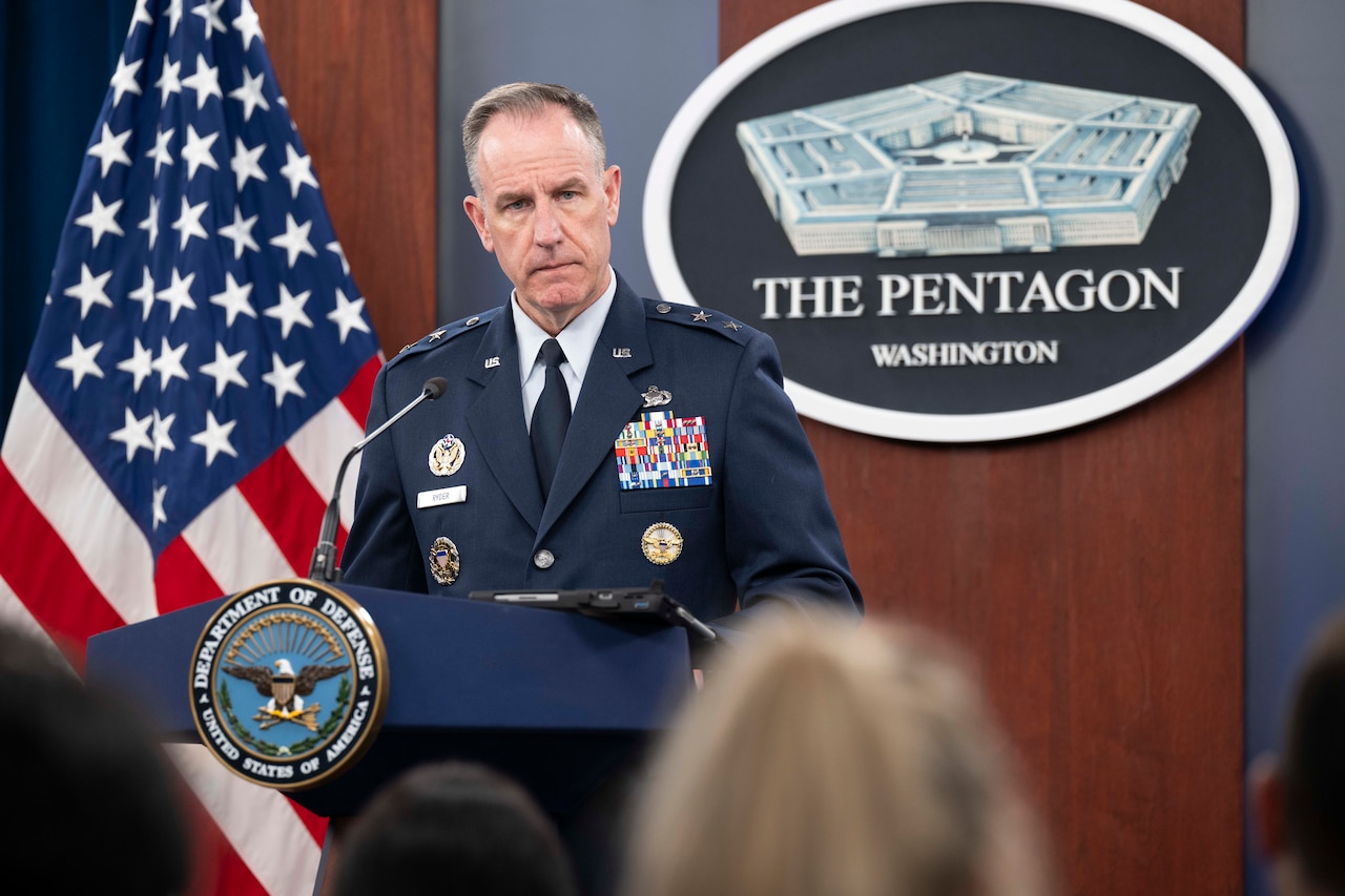 A man looks into an audience while standing at a podium.
