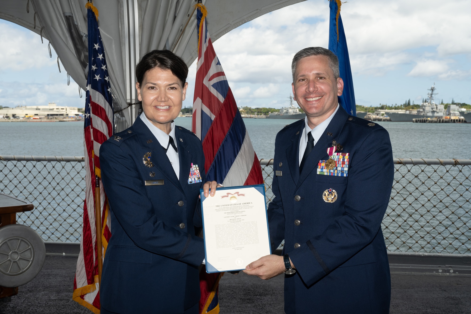 Air Force group commander presents citation to an Air Force squadron commander during a change of command ceremony.