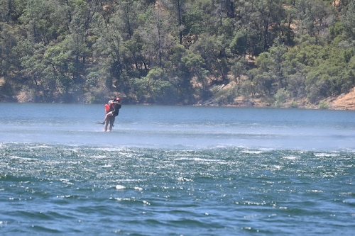 A Sikorsky HH-60G Pave Hawk lowers a pair of U.S. Air Force pararescue jumpers from the 129th Rescue Wing into Englebright Lake, Smartsville, California on June 6, 2024