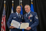 Brig. Gen. David Cochran, Commander of the West Virginia Air National Guard, presents the Bronze Star certificate to Master Sgt. Andrew Mencin, a firefighter assigned to the 130th Airlift Wing during a ceremony held June 8, 2024, at McLaughlin Air National Guard Base, Charleston, W.Va. Mencin earned the Bronze Star for actions during a six-month deployment in support of Operation Inherent Resolve. (U.S. Air National Guard photo by 2nd Lt. De-Juan Haley)