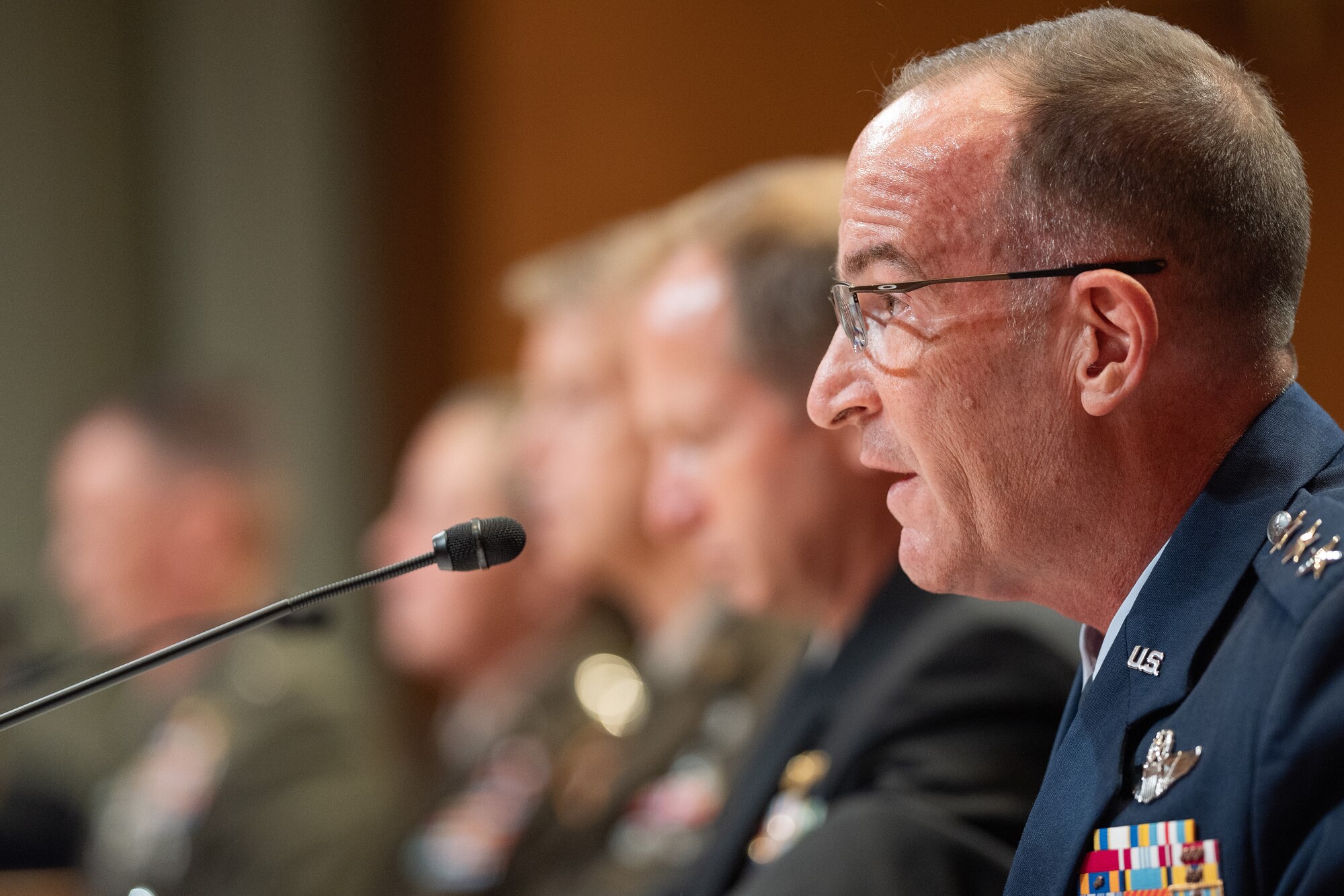 Military members sit at a table during a senate hearing.