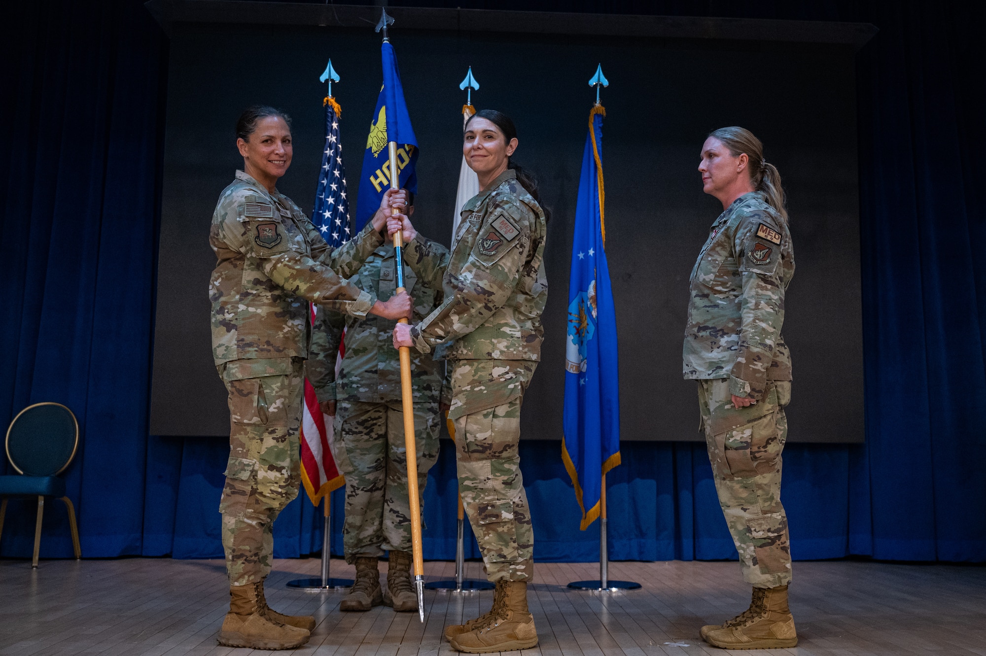 U.S. Air Force Lt. Col. Joanna Cooley, middle, accepts command of the 51st Healthcare Operations Squadron from Col. Mocha Robinson, 51st Medical Group commander, left, during a change of command ceremony at Osan Air Base, Republic of Korea, June 18, 2024. Prior to taking command, Cooley served as the 20th MDG primary care flight commander for Shaw Air Force Base, South Carolina. (U.S. Air Force photo by Airman 1st Class Chase Verzaal)