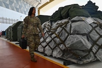 U.S. Air Force Staff Sgt. Priscilla Ramirez, 37th Expeditionary Bomb Squadron all-source intelligence analyst non-commissioned officer in-charge, walks equipment into a Hangar where the 37th EBS is operating out of at Andersen Air Force Base, Guam, June 17, 2024. The U.S. Air Force routinely deploys a variety of aircraft and units throughout the Indo-Pacific area of operations in support of geographic combatant command objectives and training. (U.S. Air Force photo by Staff Sgt. Jake Jacobsen)