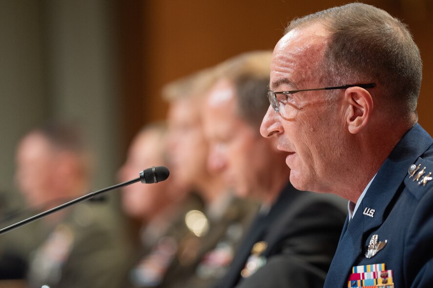 Military members sit at a table during a senate hearing.