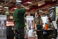 Staff Sgt. Siya Liu, 349th Aerospace Medical Squadron health services management technician, Travis Air Force Base, Calif., greets a patient at Ivanna Eudora Kean High School in St. Thomas, U.S. Virgin Islands, June 1, 2024. Ivanna Eudora Kean High School was transformed into a reception and treatment area during Virgin Islands Wellness Innovative Readiness Training June 1-8, 2024.