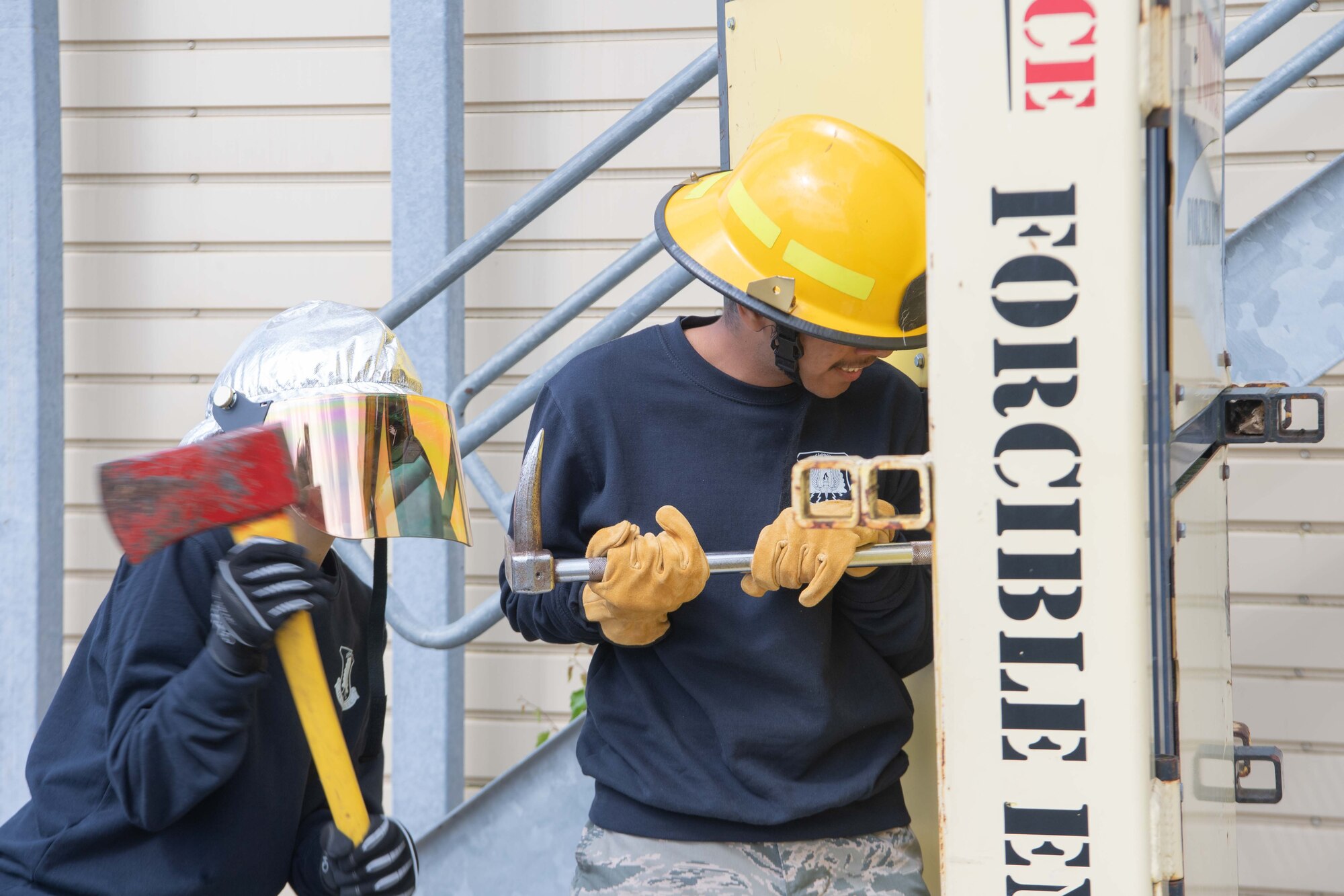 Two people force open a training door