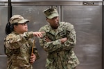 Tech. Sgt. Alexandria Fernando, public health technician, 126th Medical Group, 126 Air Refueling Wing Scott Air Force Base, Illinois, and U.S. Navy Petty Officer William Fields, preventive medicine corpsman, U.S. Naval Hospital in Naples Italy, discussion inspection of the Navy exchange food court restaurants in Capodichino, Italy, June 5, 2024.