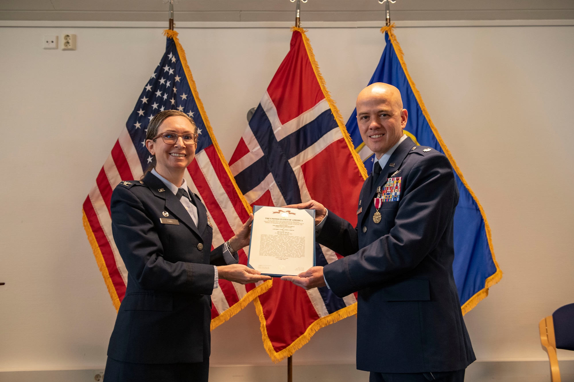 Col. Valarie A. Long, 423d Air Base Group commander, left, presents Lt. Col. Joseph H. Manning, 426th Air Base Squadron outgoing commander, with a Meritorious Service Medal during the 426th ABS change of command ceremony on Jåttå Military Compound, Norway