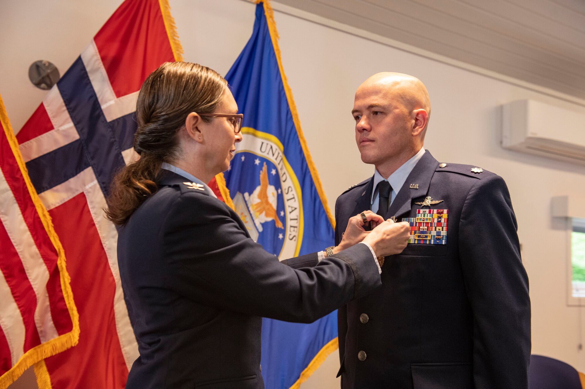 Col. Valarie A. Long, 423d Air Base Group commander, left, presents Lt. Col. Joseph H. Manning, 426th Air Base Squadron outgoing commander, with a Meritorious Service Medal during the 426th ABS change of command ceremony on Jåttå Military Compound, Norway