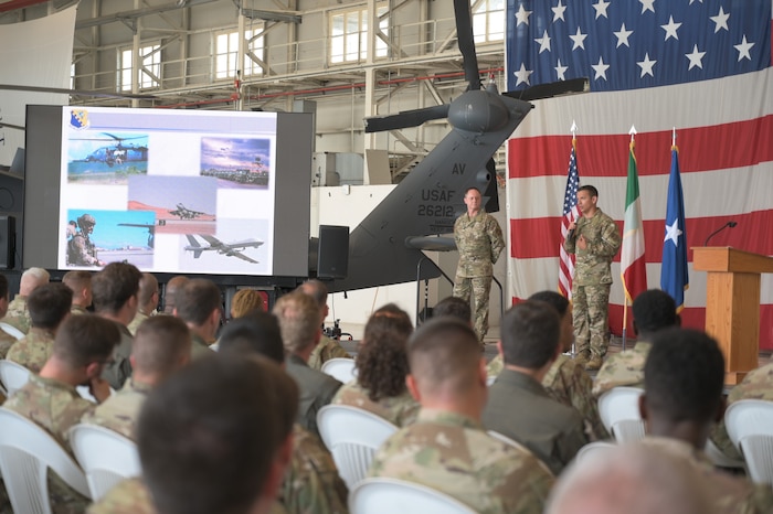 A crowd watches to men speak