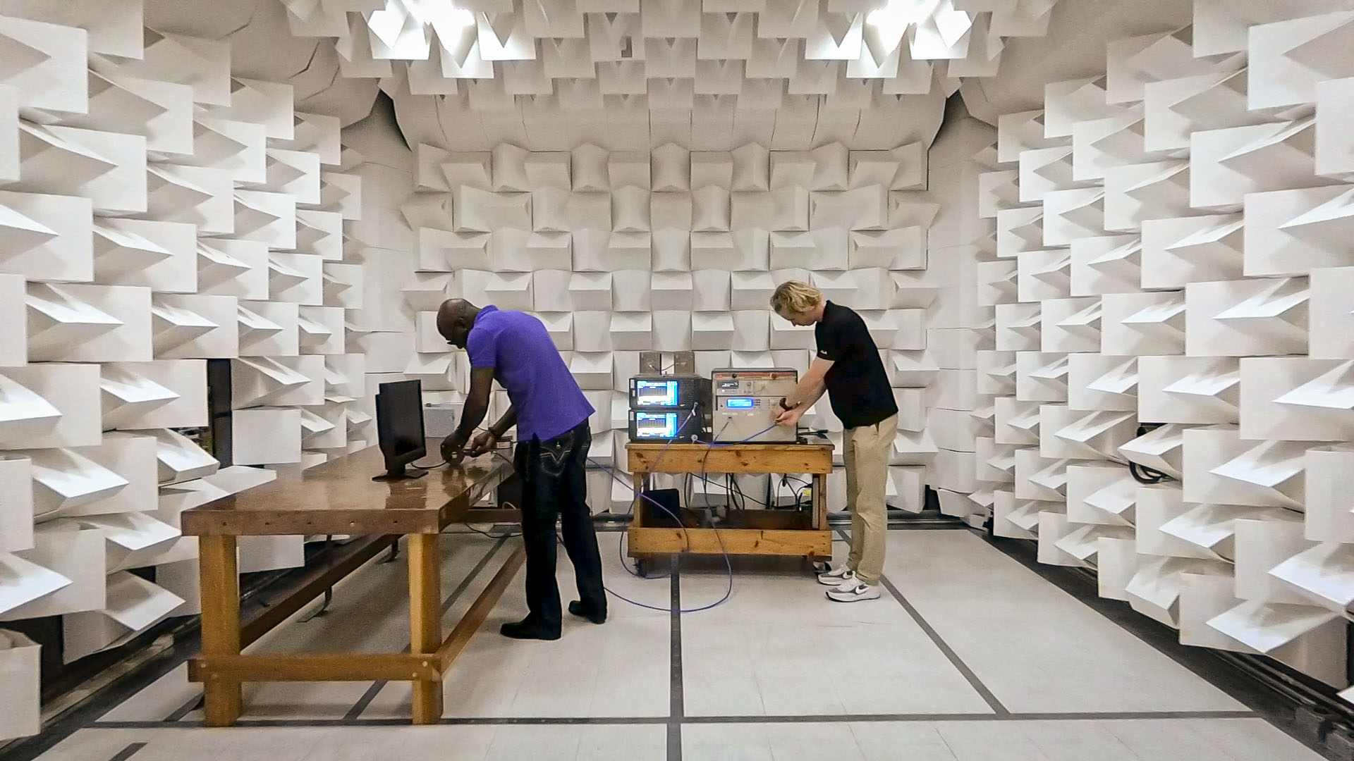 Frederick Duffy (left) and Zach Wallert (right), electrical engineers, conduct testing in an anechoic chamber, which is a shielded enclosure used to test electronic equipment for electromagnetic interference/electromagnetic compatibility (EMI/EMC) compliance.