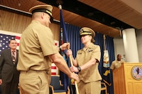 Cmdr. John Copeland (left) passes command of Information Warfare Training Command Virginia Beach to Cmdr. Laura Smith (right) at a change of command ceremony in Layton Hall on June 6, 2024.