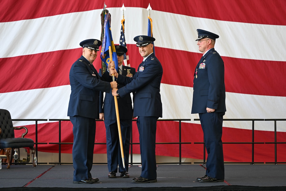 Col. Jonathan Tucker, 314th Airlift Wing commander, passes the guidon to Col. Chad Overton, incoming 314th Operations Group commander during a change of command ceremony at Little Rock Air Force Base, Arkansas, June 13, 2024. The passing of the guidon is a tradition symbolizing the transfer of leadership.