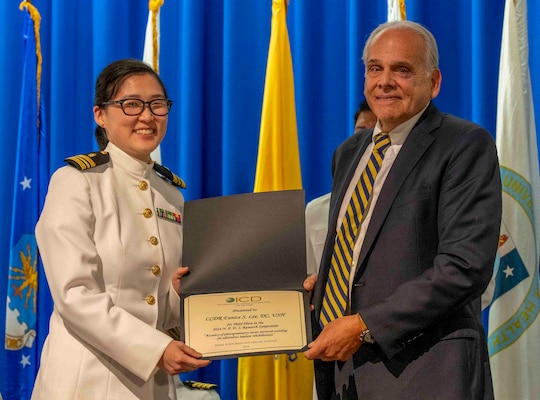 240607-N-JC800-1107 BETHESDA, Md. (Jun. 7, 2024) –Dr. Ira Titunik, president of the United States International College of Dentistis, presented the award for research to Cmdr. Eunice Lee during the graduation ceremony for the Naval Postgraduate Dental School. (U.S. Navy photo by Mass Communication Specialist 1st Class Heath Zeigler/Released)