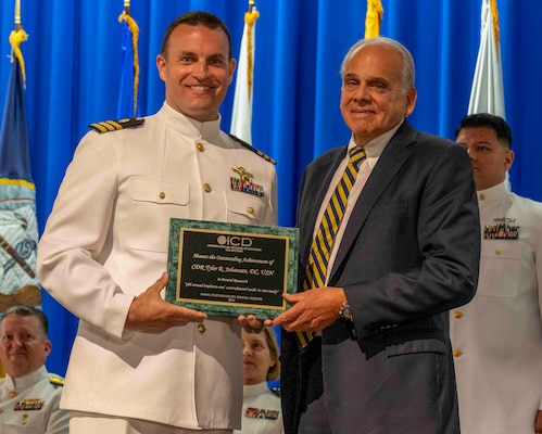 240607-N-JC800-1108 BETHESDA, Md. (Jun. 7, 2024) –Dr. Ira Titunik, president of the United States International College of Dentistis, presented the award for research to Cmdr. Tyler Johansen during the graduation ceremony for the Naval Postgraduate Dental School. (U.S. Navy photo by Mass Communication Specialist 1st Class Heath Zeigler/Released)