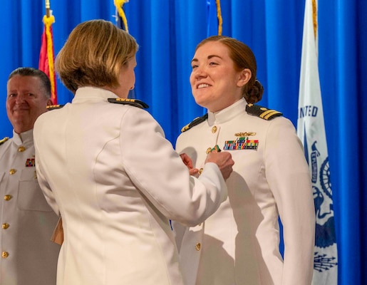 240607-N-JC800-1118 BETHESDA, Md. (Jun. 7, 2024) – Capt. Katharne Shobe, commanding officer of Naval Medical Leader and Professional Development Command, awards Lt. Julia Collazo with the Navy and Marine Corps Acheivement Medal during the graduation ceremony for the Naval Postgraduate Dental School. (U.S. Navy photo by Mass Communication Specialist 1st Class Heath Zeigler/Released)