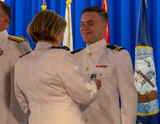 240607-N-JC800-1139 BETHESDA, Md. (Jun. 7, 2024) – Capt. Katharne Shobe, commanding officer of Naval Medical Leader and Professional Development Command, awards Lt. Timothy Daudelin with the Navy and Marine Corps Commendation Medal during the graduation ceremony for the Naval Postgraduate Dental School. (U.S. Navy photo by Mass Communication Specialist 1st Class Heath Zeigler/Released)