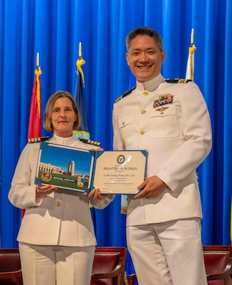 240607-N-JC800-1194 BETHESDA, Md. (Jun. 7, 2024) – Capt. Katharne Shobe, commanding officer of Naval Medical Leader and Professional Development Command, presents Lt. Cmdr. Yuning Weber with his certificate of completion of his residency training in Comprehensive Dentistry during the graduation ceremony for the Naval Postgraduate Dental School. (U.S. Navy photo by Mass Communication Specialist 1st Class Heath Zeigler/Released)