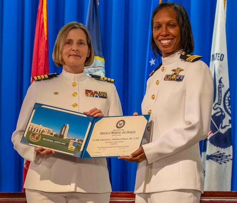 240607-N-JC800-1209 BETHESDA, Md. (Jun. 7, 2024) – Capt. Katharne Shobe, commanding officer of Naval Medical Leader and Professional Development Command, presents Lt. Cmdr. Jabrenta Hubbard Reese with her certificate of completion of his residency training in Endodontics during the graduation ceremony for the Naval Postgraduate Dental School. (U.S. Navy photo by Mass Communication Specialist 1st Class Heath Zeigler/Released)