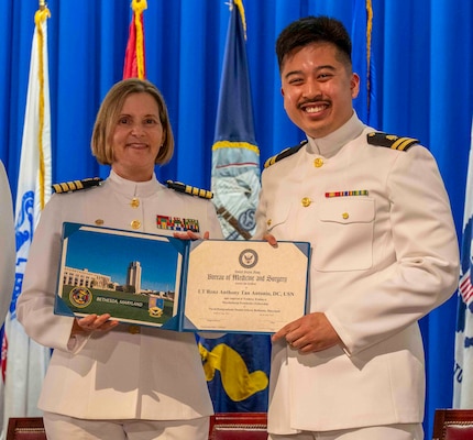 240607-N-JC800-1209 BETHESDA, Md. (Jun. 7, 2024) – Capt. Katharne Shobe, commanding officer of Naval Medical Leader and Professional Development Command, presents Lt. Renz Anthony Tan Antonio with his certificate of completion of his residency training in Maxillofacial Prosthetics Fellowship during the graduation ceremony for the Naval Postgraduate Dental School. (U.S. Navy photo by Mass Communication Specialist 1st Class Heath Zeigler/Released)