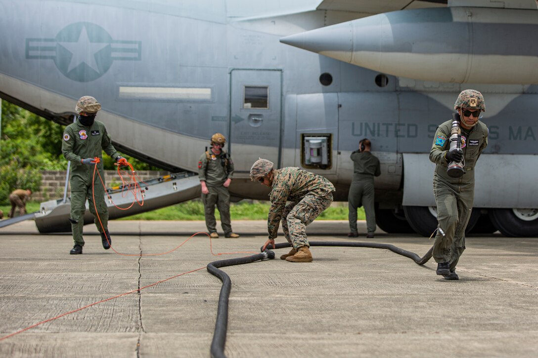 U.S. Marines with Marine Wing Support Squadron (MWSS) 371, Marine Air Control Group 38, 3rd Marine Aircraft Wing, and Philippine Sailors run a fuel line after refueling a KC-130J Super Hercules with Marine Aerial Refueler Transport (VMGR) 352, Marine Aircraft Group 11, 3rd MAW, during forward arming and refueling point operations at Laoag International Airport, Laoag, Philippines, June 15, 2024. The FARP supported aircraft with Marine Aerial Refueler Transport (VMGR) 352, Marine Aircraft Group 11, 3rd MAW, and 1st Special Operations Squadron during Marine Aviation Support Activity 24. MASA is an annual Philippine-U.S. military exercise focused on mutual defense, strengthening relationships, and rehearsing emerging aviation concepts. (U.S. Marine Corps photo by Cpl. Nikolas Mascroft)