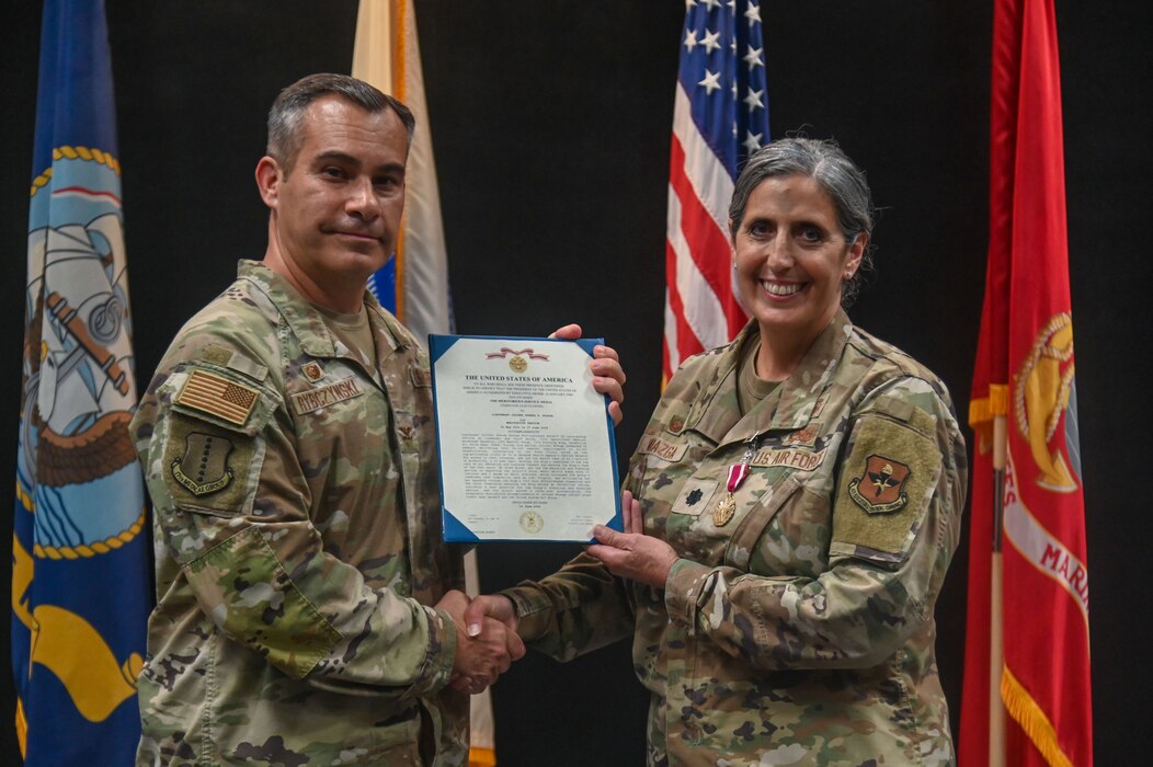 U.S. Air Force Col. Ian Rybczynski, 17th Medical Group commander, presents Lt. Col. Brenda Miazga, 17th Operational Medical Readiness Squadron outgoing commander with a Meritorious Service Medal at the Powell Event Center, Goodfellow Air Force Base, Texas, June 17, 2024. The 17th OMRS is responsible for the health and medical readiness of the entire 17th Training Wing. (U.S. Air Force photo by Airman 1st Class James Salellas)