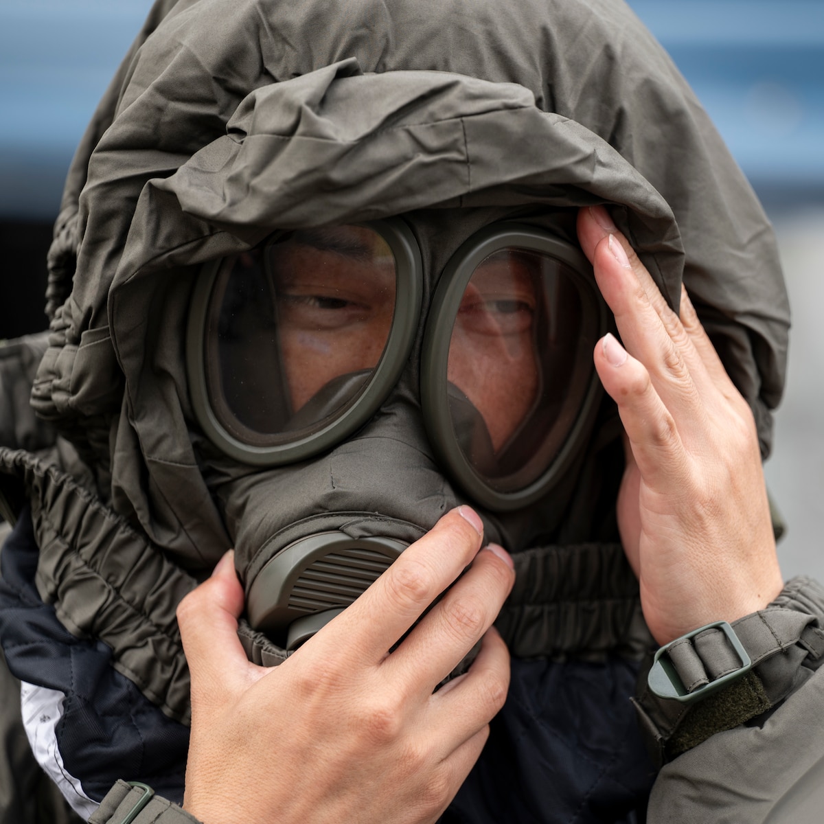 A member assigned to the Japan Air Self-Defense Force Operations Support Wing dons a gas mask.