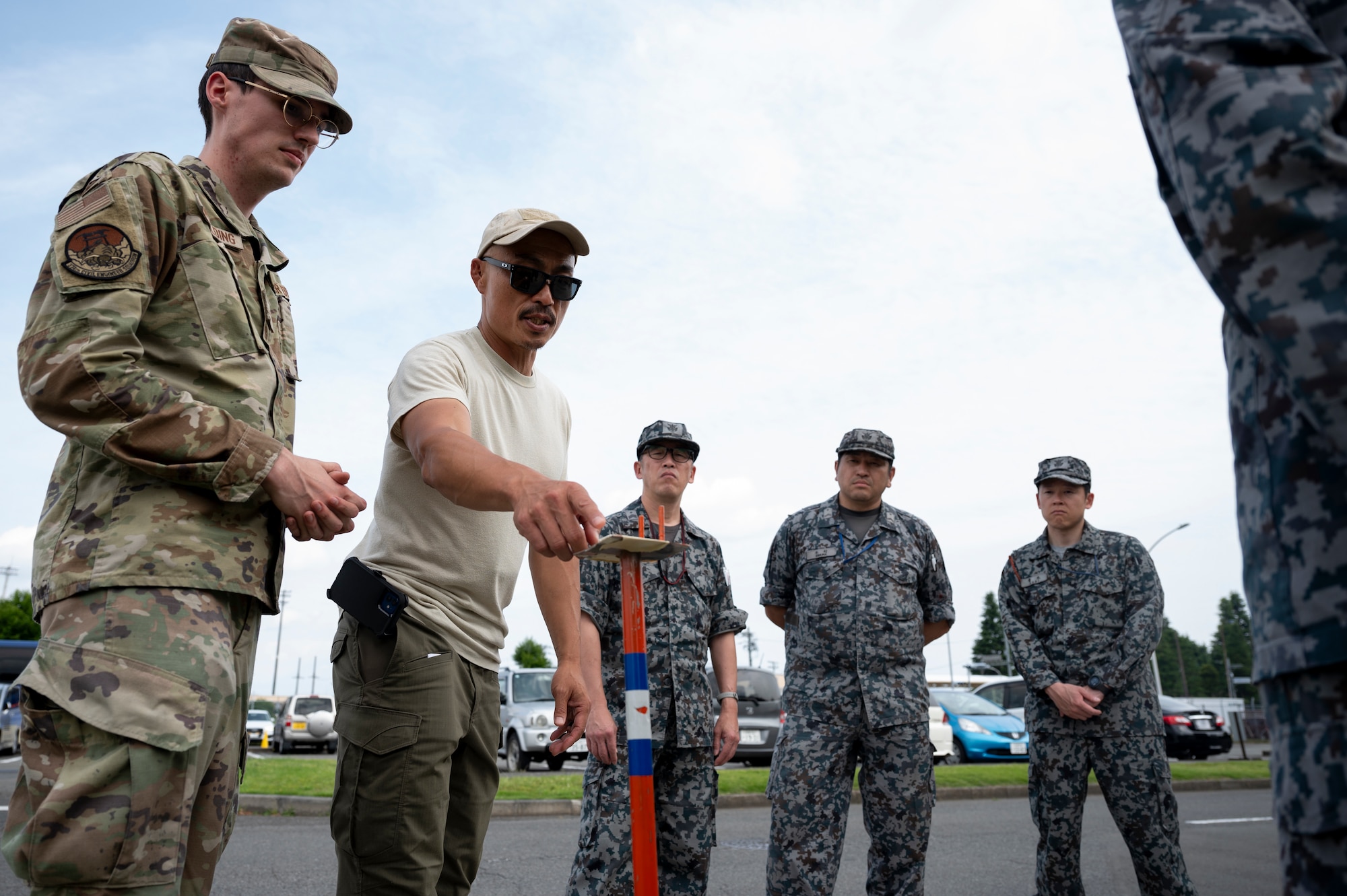 Members review a stanchion with M9 chemical agent detection paper while conducting post-attack reconnaissance sweeps.
