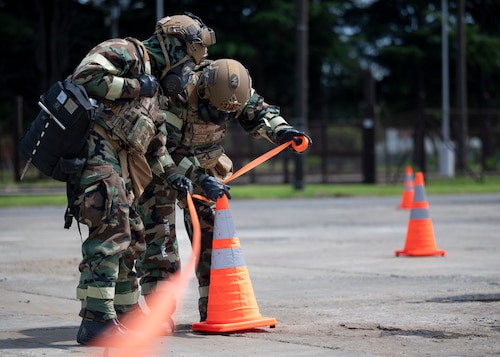 Emergency management journeymen cordon off a simulated contaminated area.