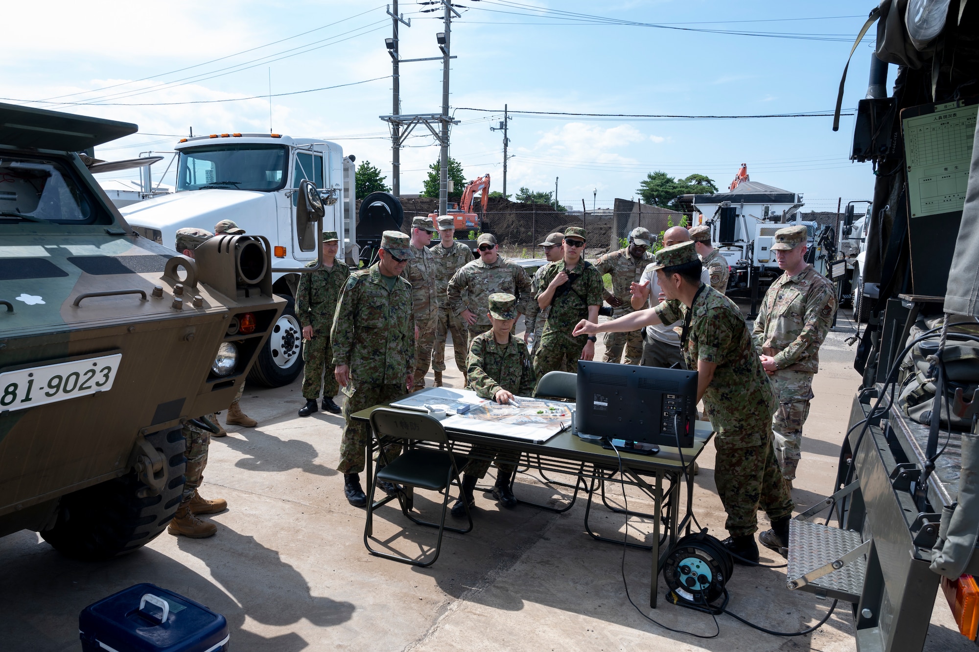 Members of the 374th Civil Engineer Squadron and Japan Ground Self-Defense Force review the capabilities of a global command center.
