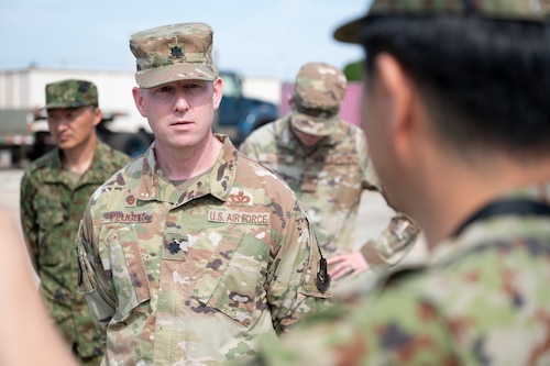 An airman speaks to a Japan Ground Self-Defense Force member.