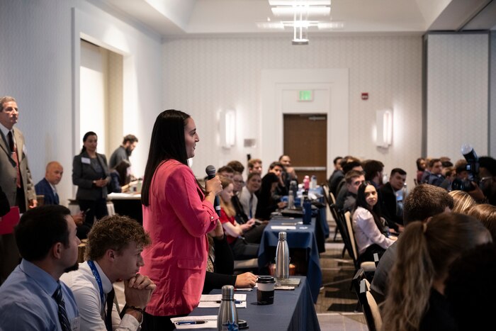 Student intern asks question at the symposium