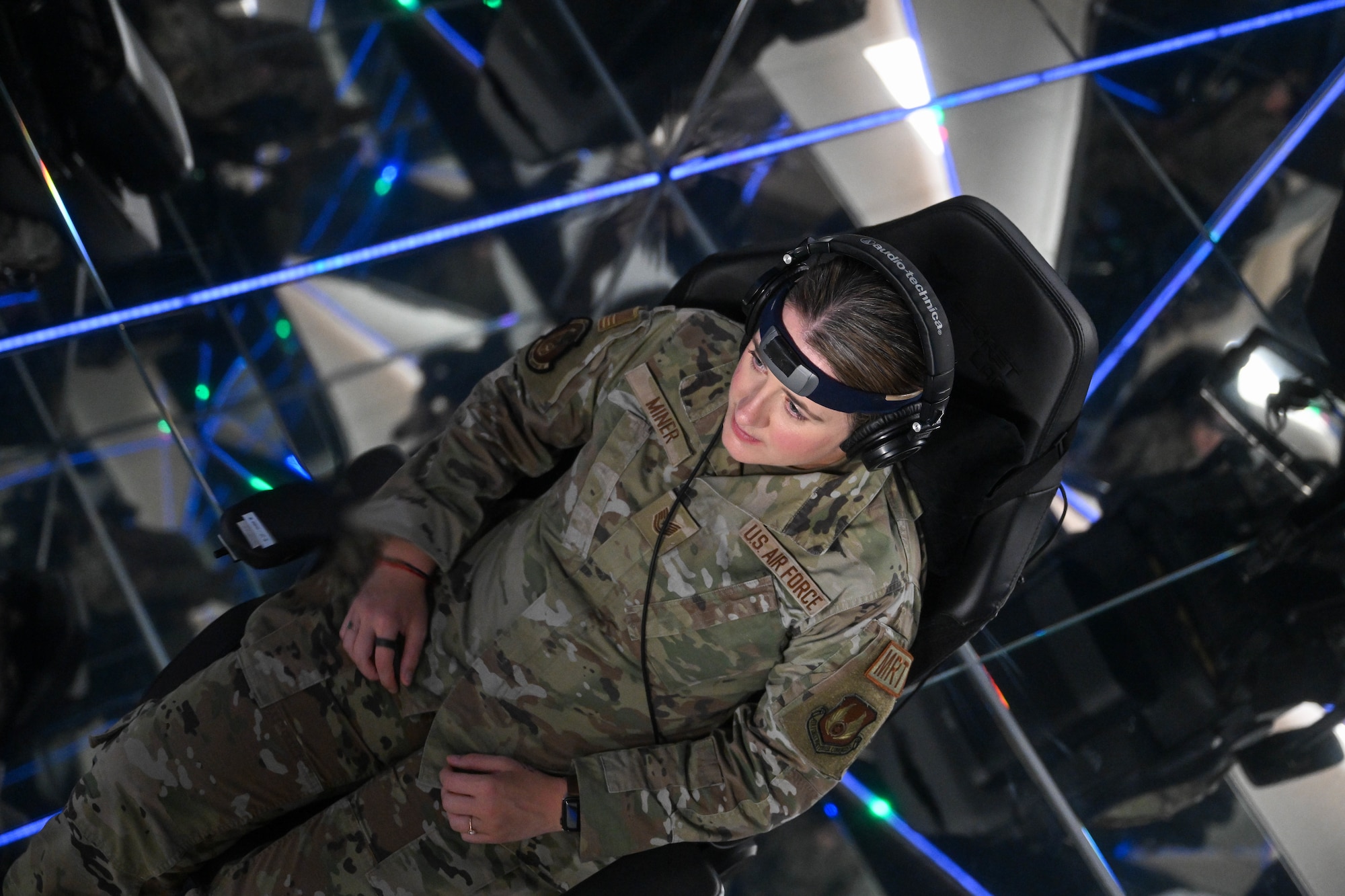 An Airman sits in a sensory deprivation pod surrounded by reflective mirrors