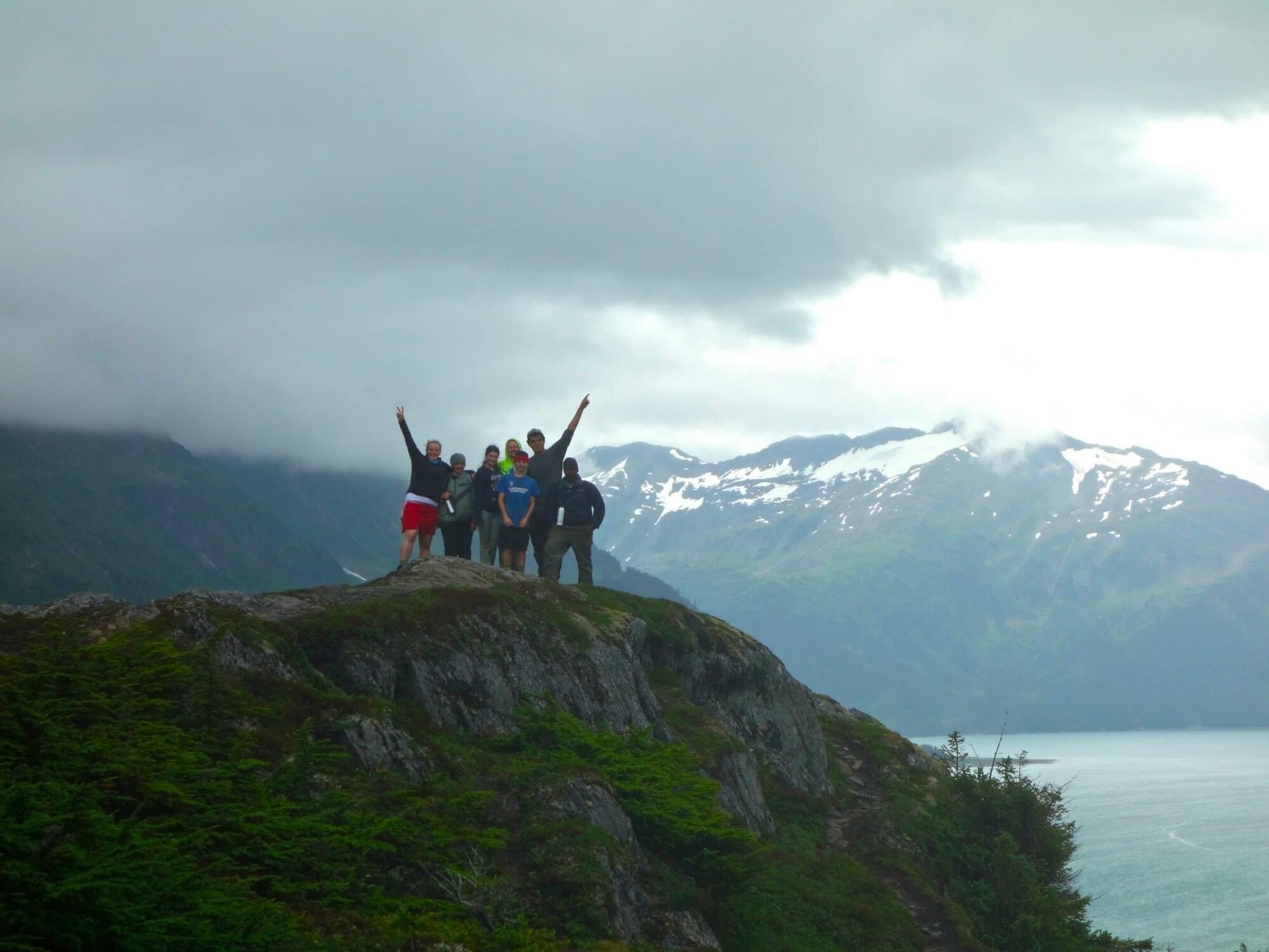 A group of people stand on a mountain