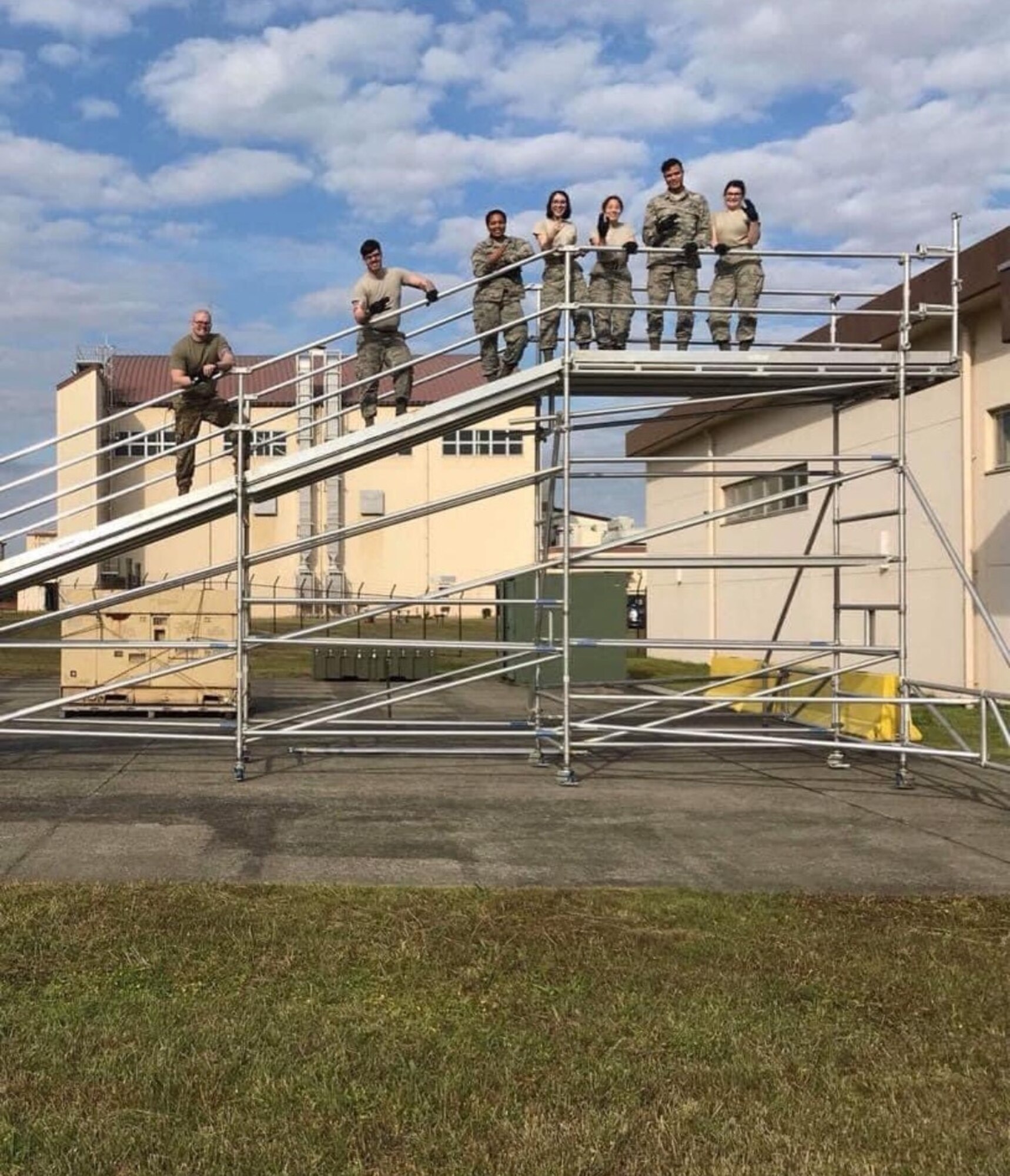 Airmen stand on scaffolding