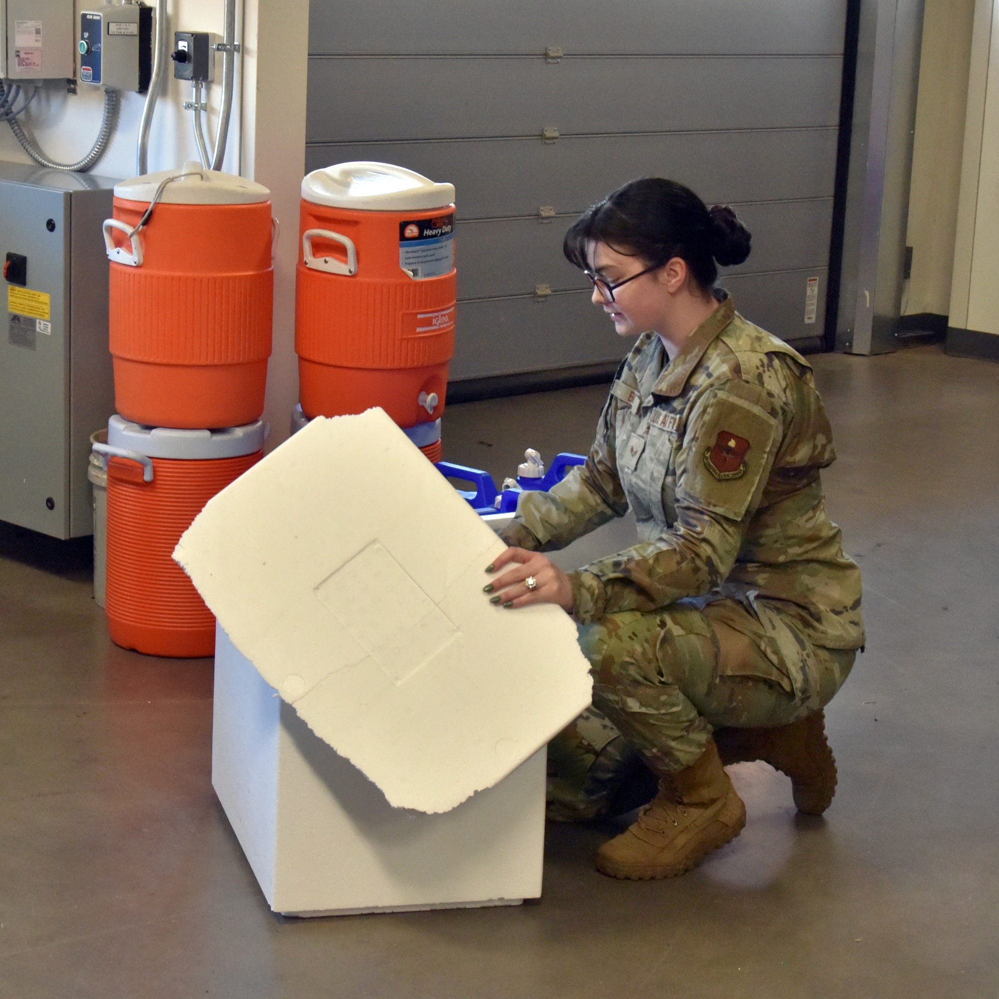 An Airman looks into a box.