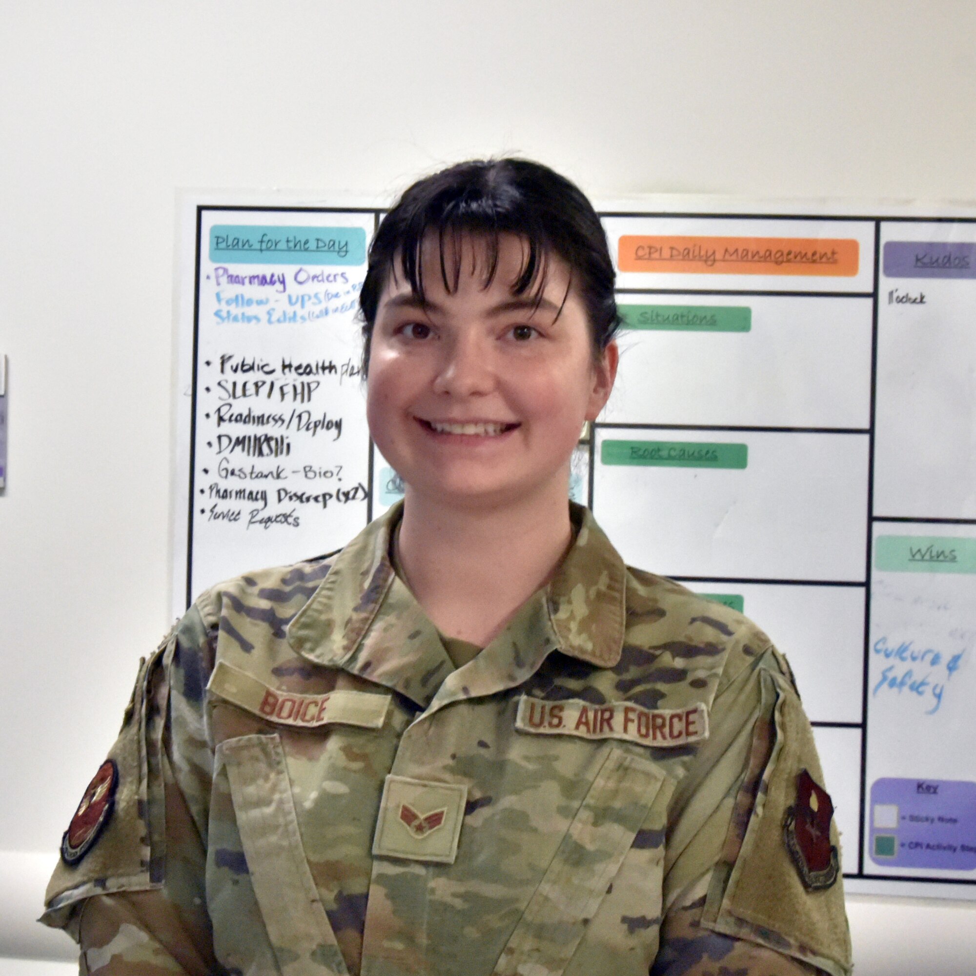 An Airman stands in front of a white board.