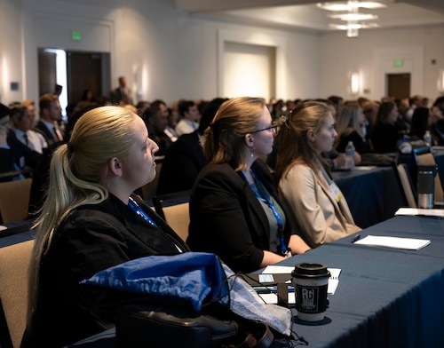 College students listening to speakers at college intern symposium