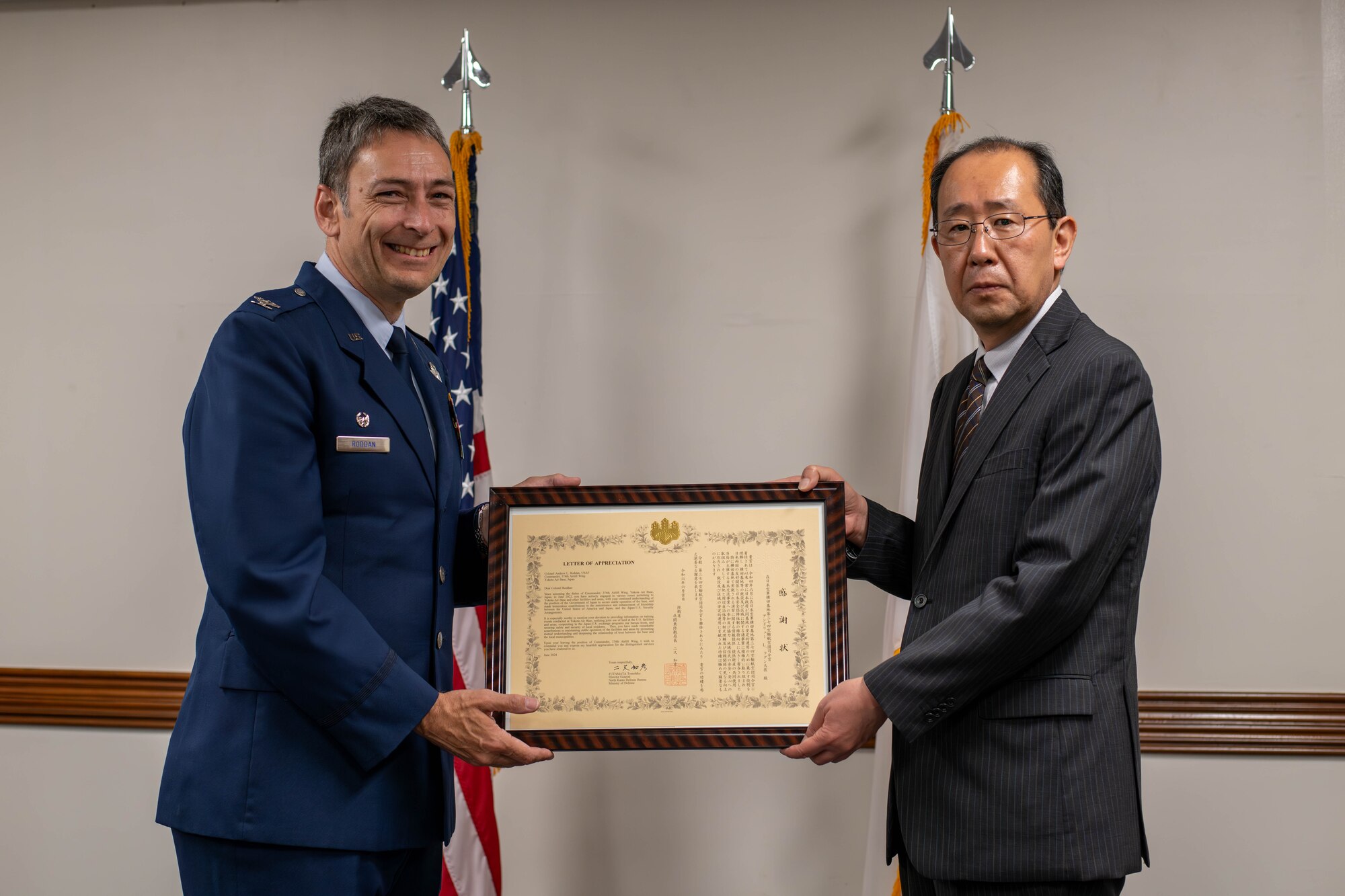 U.S. Air Force Col. Andrew Roddan, 374th Airlift Wing commander, left, is presented with a letter of appreciation from Tomohiko Futamata, North Kanto Defense Bureau director general.
