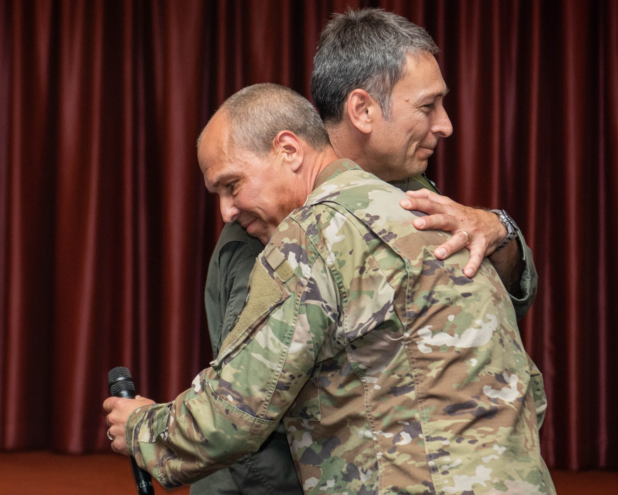 U.S. Air Force Col. Andrew Roddan, 374th Airlift Wing commander, and Col. Brett Cochran, 374th AW deputy commander share a hug.